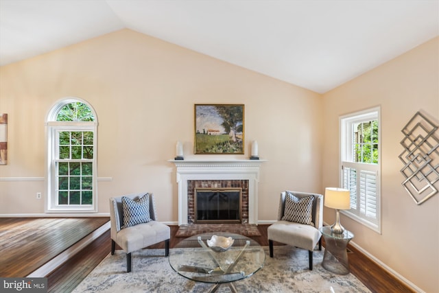 2032 Franklin Cluster Ct, Falls Church, VA 22043 - living area with healthy amount of natural light, wood finished floors, vaulted ceiling, a brick fireplace, and baseboards