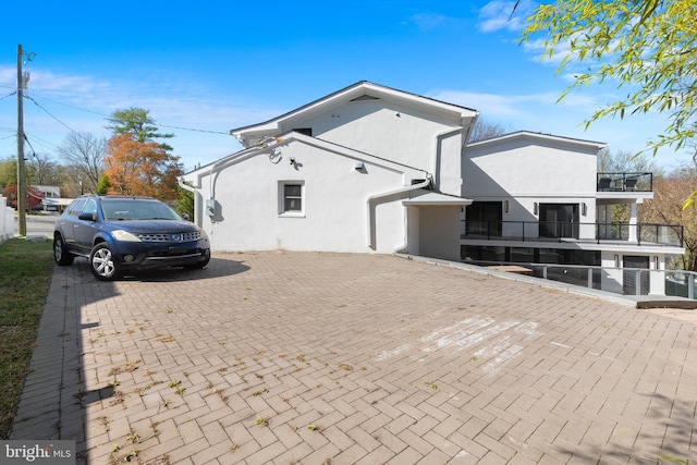 2100 S Pierce St, Arlington, VA 22202 - view of home's exterior with stucco siding, a balcony, and decorative driveway