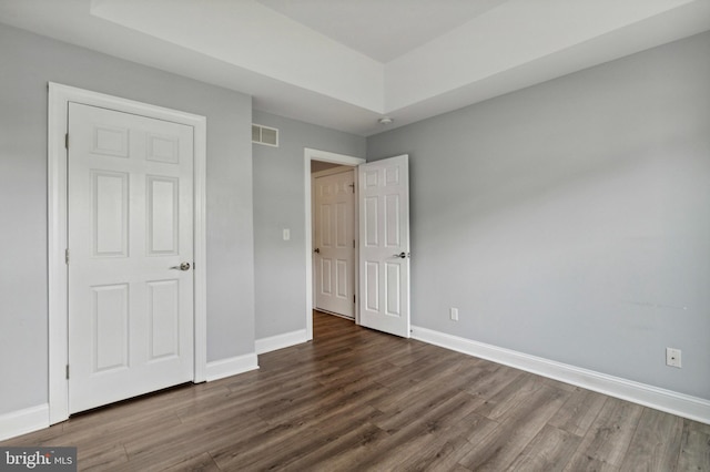unfurnished bedroom with wood finished floors and baseboards