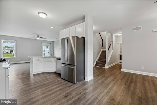 kitchen featuring appliances with stainless steel finishes, a peninsula, a ceiling fan, white cabinets, and recessed lighting