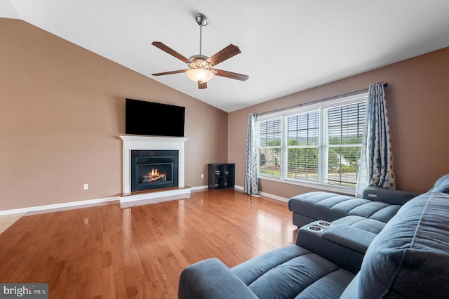 81 Toulouse Ln, Martinsburg, WV 25403 - living area featuring a ceiling fan, vaulted ceiling, light wood-type flooring, a lit fireplace, and baseboards