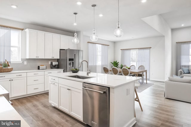 35243 Duck Haven Rd, Selbyville, DE 19975 - kitchen featuring stainless steel appliances, a sink, open floor plan, a kitchen island with sink, and light wood-style floors