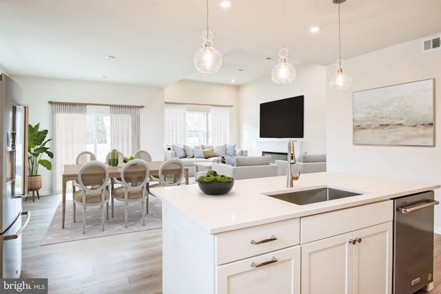 35243 Duck Haven Rd, Selbyville, DE 19975 - kitchen with a sink, light wood finished floors, appliances with stainless steel finishes, pendant lighting, and light countertops