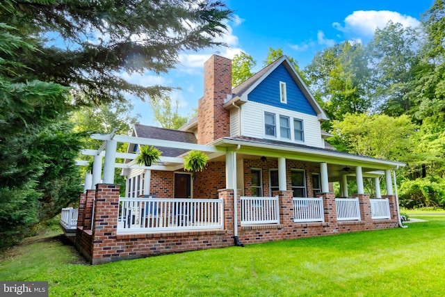 43 Shea Dr, Mohnton, PA 19540 - view of front of house featuring covered porch, a chimney, a front lawn, and brick siding