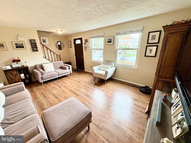 12415 Morning Light Ter, Gaithersburg, MD 20878 - living area with stairs, light wood-type flooring, a textured ceiling, and baseboards