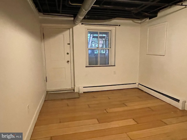 2732 Maryland Ave, Baltimore, MD 21218 - basement featuring wood finished floors, a baseboard radiator, and baseboards