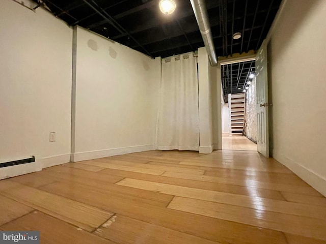 2732 Maryland Ave, Baltimore, MD 21218 - finished basement with light wood finished floors, baseboards, and a baseboard heating unit