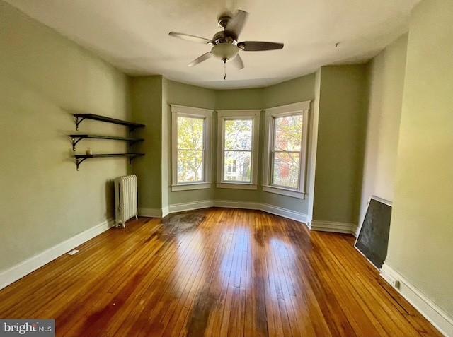 2732 Maryland Ave, Baltimore, MD 21218 - unfurnished living room with radiator, wood-type flooring, a ceiling fan, and baseboards