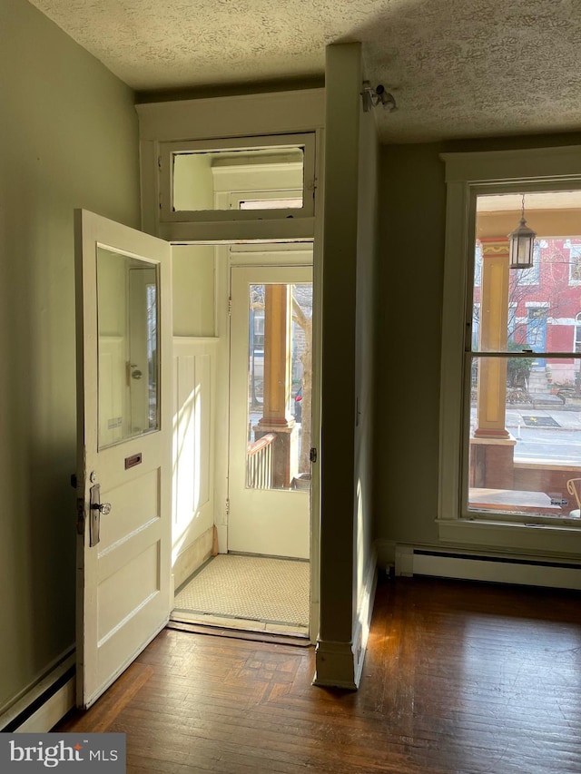 2732 Maryland Ave, Baltimore, MD 21218 - entrance foyer featuring a baseboard heating unit, a baseboard radiator, a textured ceiling, wood finished floors, and baseboards