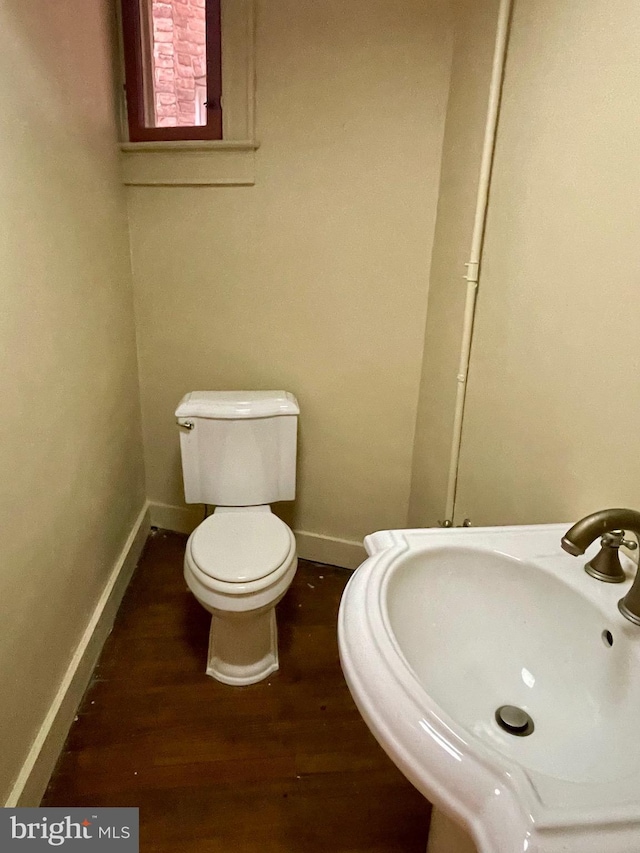 2732 Maryland Ave, Baltimore, MD 21218 - half bath featuring toilet, a sink, wood finished floors, and baseboards