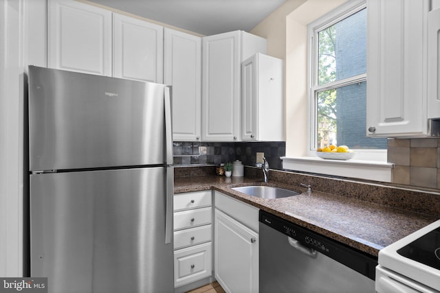 1742 U St NW Unit 101, Washington, DC 20009 - kitchen with appliances with stainless steel finishes, a sink, white cabinetry, and backsplash