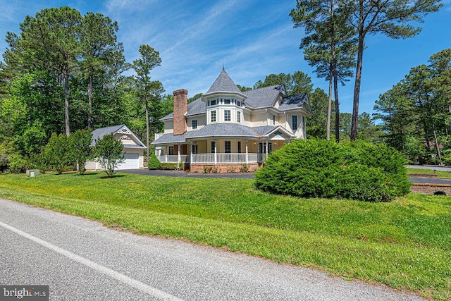 101 Port Arthur Ct, Ocean Pines, MD 21811 - victorian-style house featuring covered porch, a garage, a front lawn, and an outbuilding