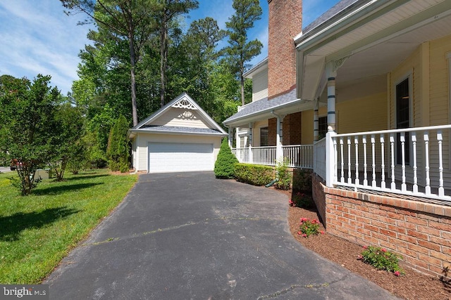 101 Port Arthur Ct, Ocean Pines, MD 21811 - view of side of home with a detached garage, a chimney, a lawn, an outdoor structure, and a porch
