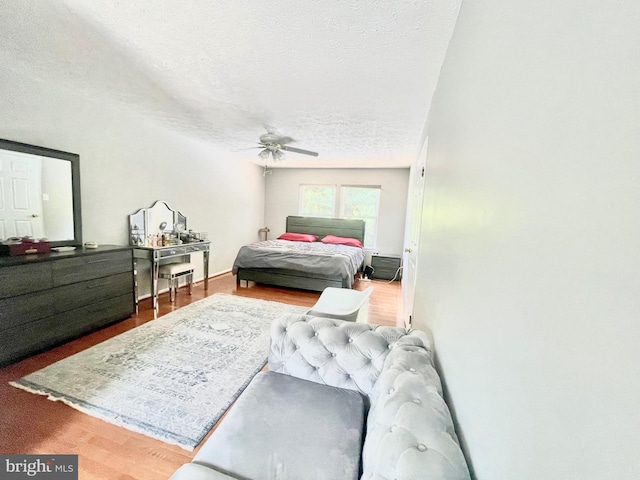 bedroom with a textured ceiling, wood finished floors, and a ceiling fan