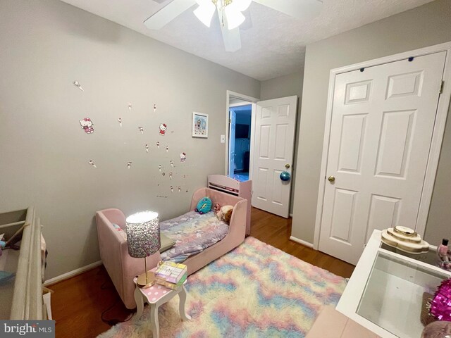 bedroom with wood finished floors, ceiling fan, and baseboards