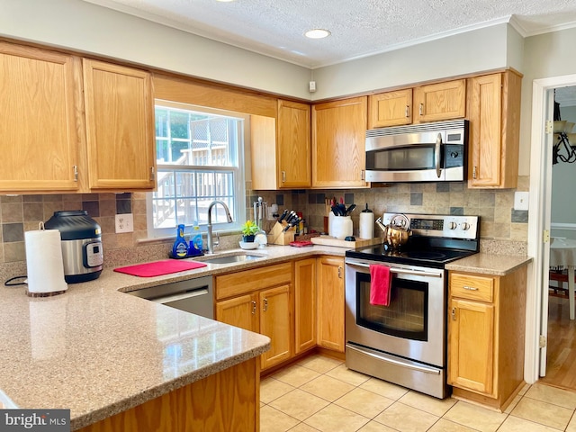 kitchen featuring appliances with stainless steel finishes, a sink, a textured ceiling, light tile patterned flooring, and light stone countertops