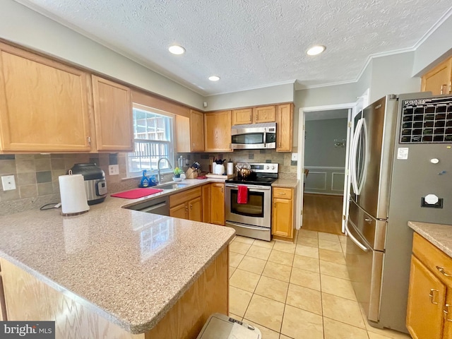 kitchen featuring stainless steel appliances, a sink, a peninsula, backsplash, and light tile patterned flooring