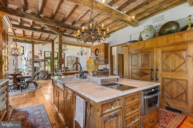 13320 Signal Tree, Potomac, MD 20854 - kitchen with a chandelier, light wood-style flooring, black electric stovetop, stainless steel oven, and a kitchen island with sink