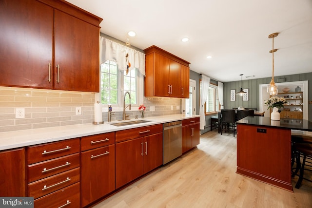 kitchen featuring stainless steel dishwasher, a sink, plenty of natural light, light wood finished floors, and recessed lighting