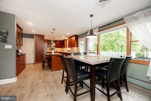 dining room with light wood-style flooring, recessed lighting, and a baseboard radiator