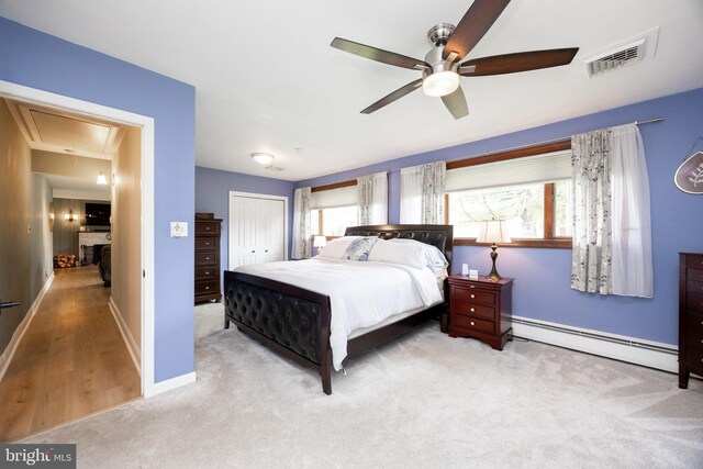 bedroom featuring a baseboard radiator, carpet, attic access, and multiple windows