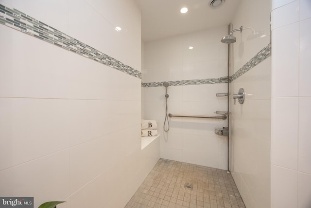 bathroom with a tile shower and recessed lighting