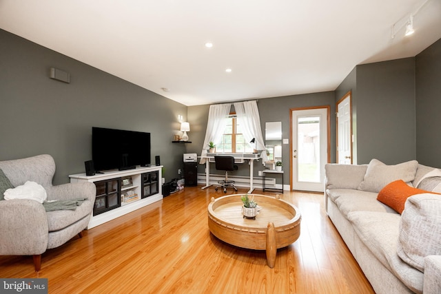 living area with a baseboard heating unit, an office area, wood finished floors, recessed lighting, and baseboards