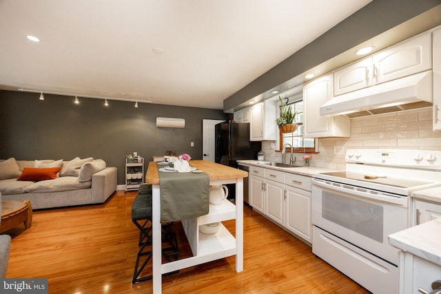 kitchen featuring electric range, under cabinet range hood, a sink, white cabinets, and backsplash
