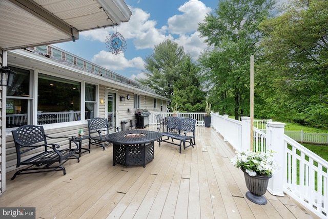 wooden deck with a fire pit and a grill