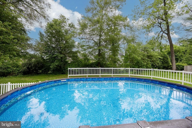 view of pool with view of wooded area