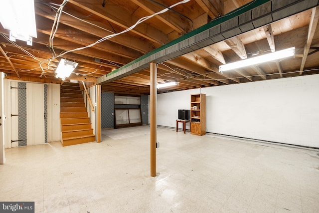 unfinished below grade area featuring tile patterned floors and stairway