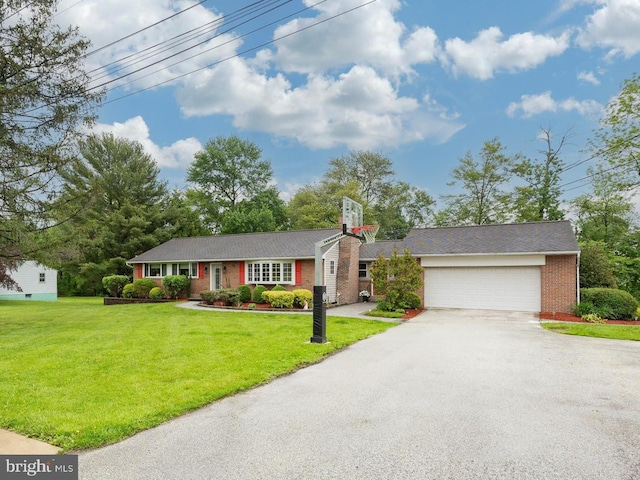 view of front facade featuring driveway, brick siding, a front yard, and an attached garage