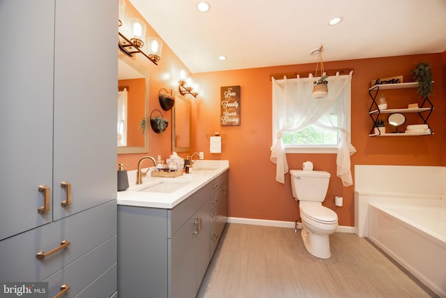 bathroom featuring toilet, a garden tub, double vanity, recessed lighting, and baseboards