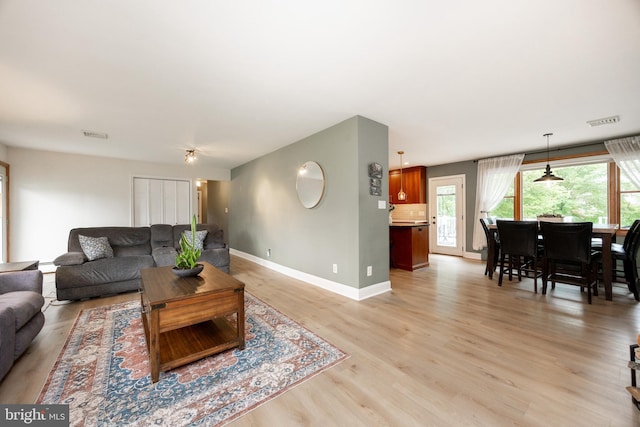 living area featuring baseboards and light wood-style floors