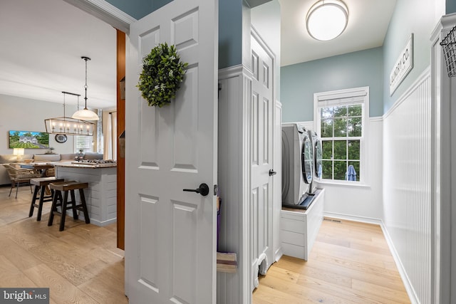 4 Saint Vincent Ct, Stafford, VA 22556 - hall featuring washer / clothes dryer, light wood finished floors, and a chandelier
