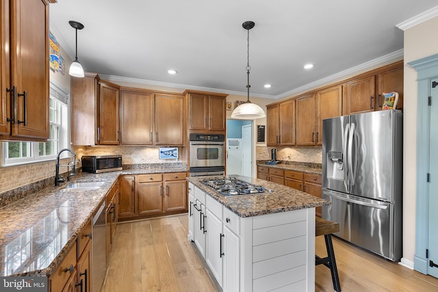 4 Saint Vincent Ct, Stafford, VA 22556 - kitchen with stainless steel appliances, brown cabinets, a sink, light wood-type flooring, and backsplash