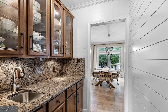 4 Saint Vincent Ct, Stafford, VA 22556 - bar area with a sink, tasteful backsplash, light wood-style flooring, hanging light fixtures, and crown molding