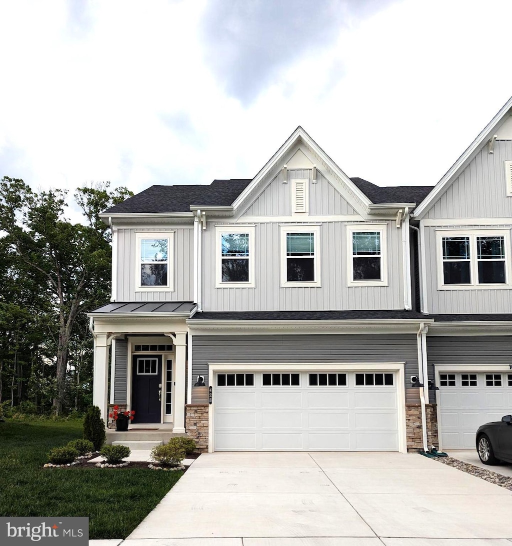 428 Waters Landing Dr, Essex, MD 21221 - view of front facade with an attached garage, concrete driveway, board and batten siding, and stone siding