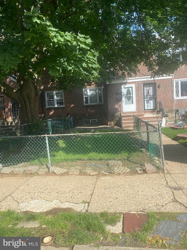 1148 Slocum St, Philadelphia, PA 19150 - obstructed view of property with a fenced front yard, brick siding, and entry steps