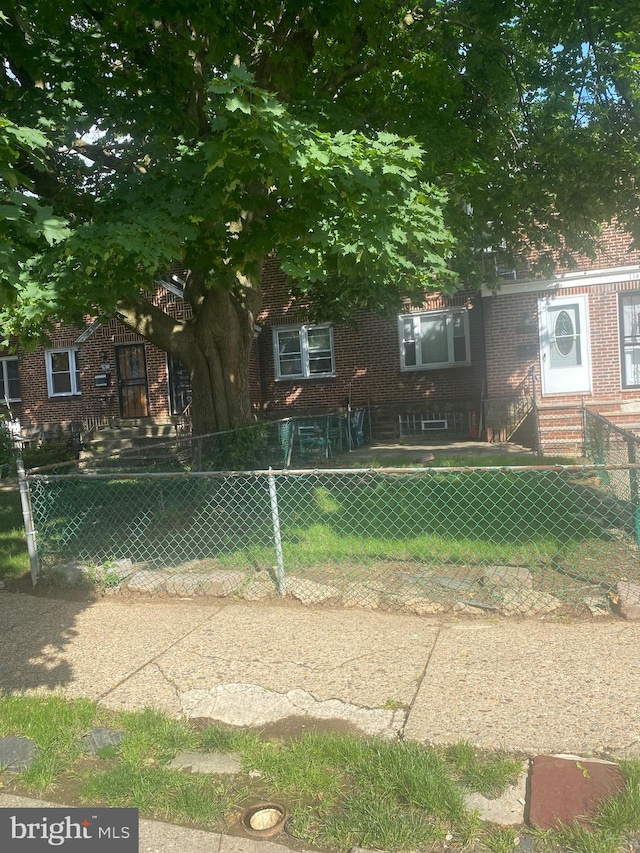 1148 Slocum St, Philadelphia, PA 19150 - obstructed view of property with brick siding, a fenced front yard, and entry steps