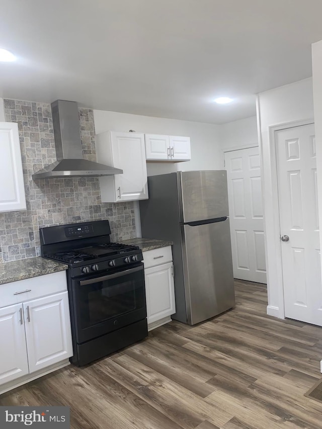 1148 Slocum St, Philadelphia, PA 19150 - kitchen featuring wall chimney exhaust hood, black range with gas stovetop, freestanding refrigerator, and white cabinets