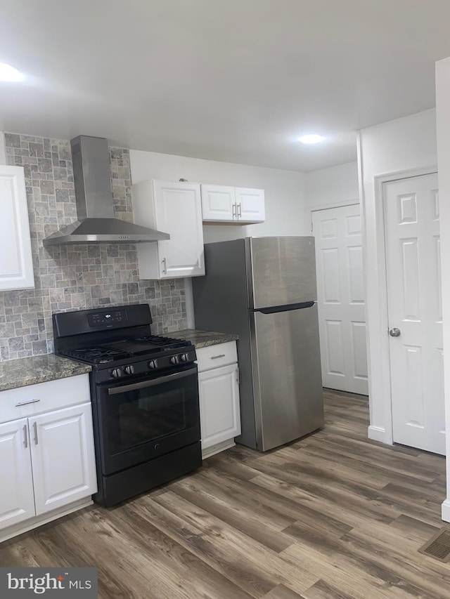 1148 Slocum St, Philadelphia, PA 19150 - kitchen featuring black gas range, wall chimney range hood, freestanding refrigerator, and white cabinets