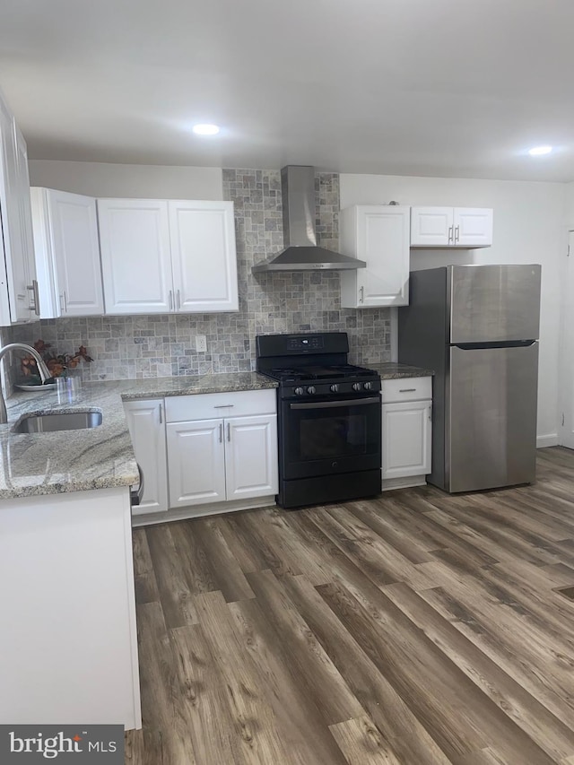 1148 Slocum St, Philadelphia, PA 19150 - kitchen featuring gas stove, wall chimney range hood, freestanding refrigerator, a sink, and dark wood-type flooring