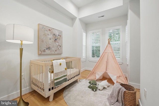 1387 N Carolina Ave NE, Washington, DC 20002 - bedroom featuring baseboards, wood finished floors, and a nursery area