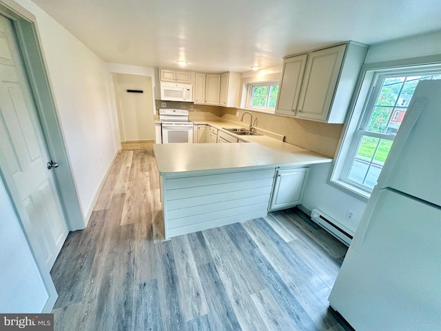 118 Hopewell St, Birdsboro, PA 19508 - kitchen with white appliances, baseboard heating, a sink, light wood-type flooring, and a peninsula