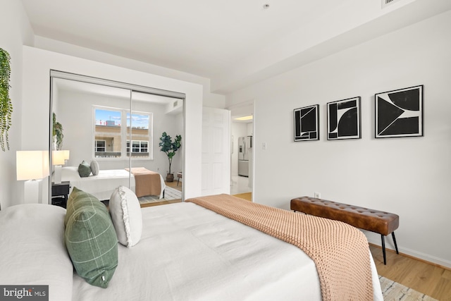 2001 12th St NW Unit 410, Washington, DC 20009 - bedroom featuring wood finished floors, stainless steel fridge with ice dispenser, baseboards, and a closet