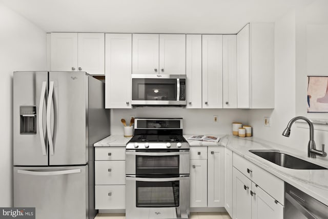 2001 12th St NW Unit 410, Washington, DC 20009 - kitchen featuring stainless steel appliances, a sink, white cabinetry, and light stone countertops