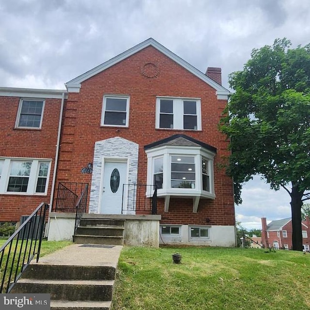 1601 Burnwood Rd, Baltimore, MD 21239 - view of front facade with brick siding, a chimney, and a front yard