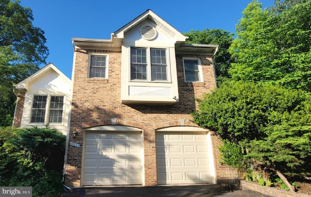 view of front facade featuring brick siding, a garage, and driveway