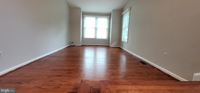 empty room featuring wood finished floors and baseboards